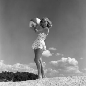 Young Woman Wearing Swimsuit Standing on Beach & Holding Beach Ball Poster Print - 18 x 24 in.