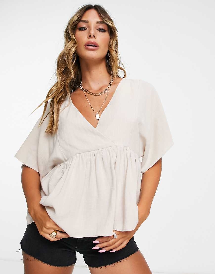 ASOS DESIGN wrap top with angel sleeve & peplum hem in natural-Neutral