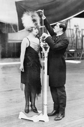 Photo: Man Taking a Measurement of a Woman with an Oversized Hat: 24x16in